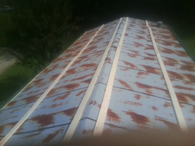 Rusted metal roof panels with new wood purlins before replacement — Storm Damage Roof Repair in Upperco by Roofing Brothers