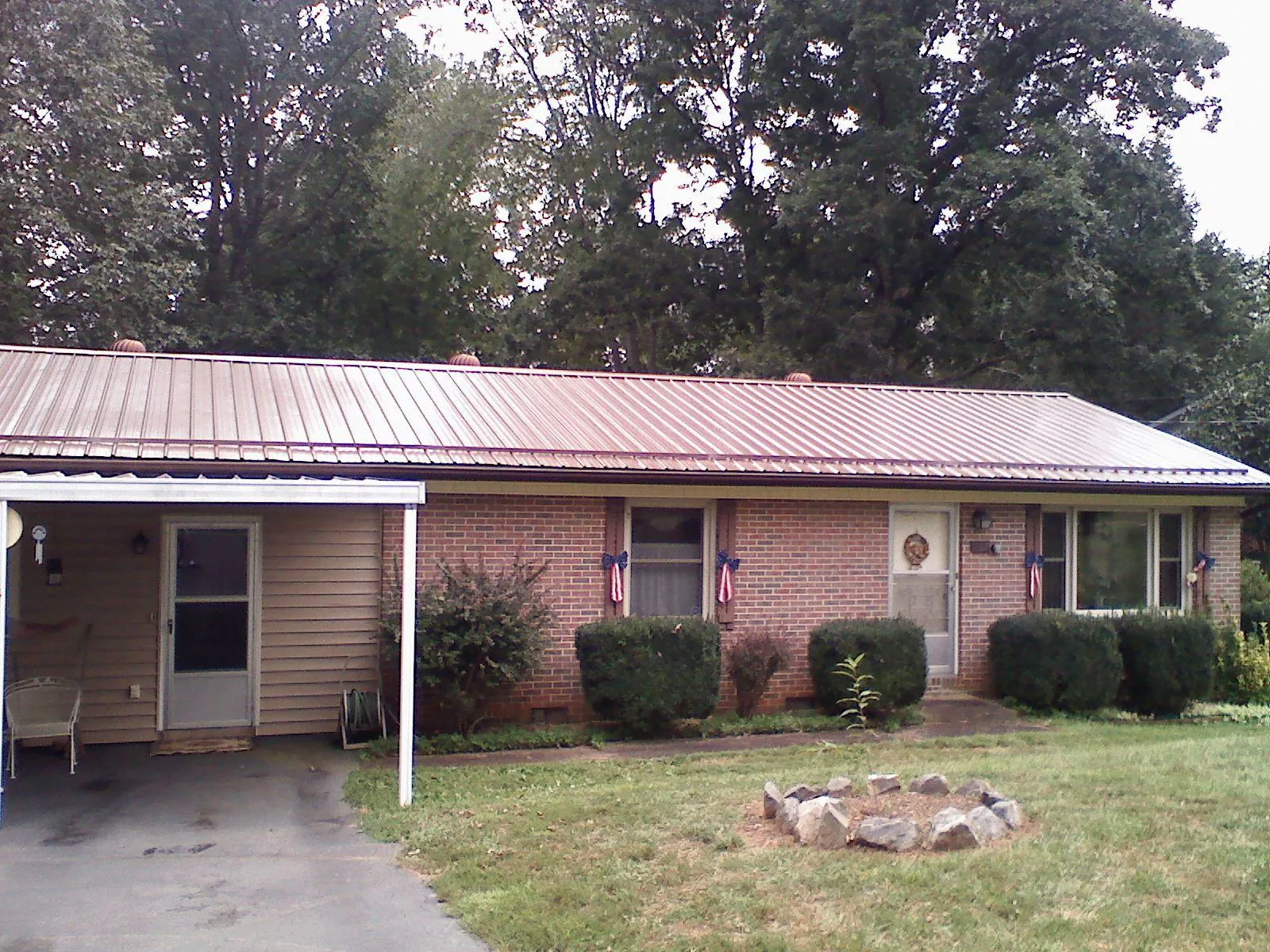 Bronze metal roof and carport on a brick ranch home — Roof Repair work by our crew in Upperco